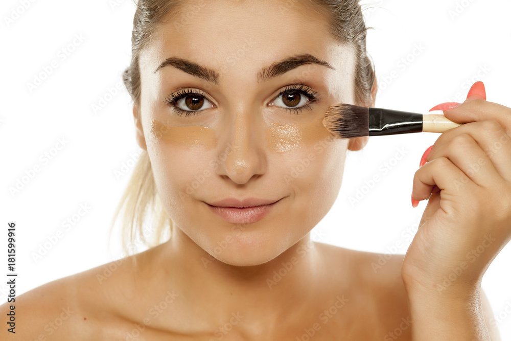 young beautiful woman applied liquid base with a brush young beautiful woman applied liquid base with a brush