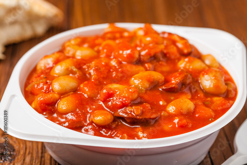 Baked beans in tomato sauce served in plastic cups.