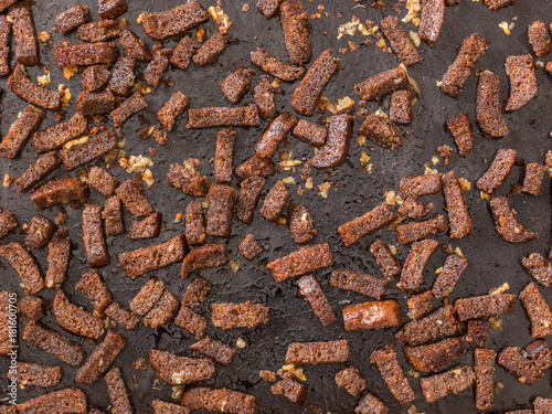 Rye crackers. Rye croutons in oil with garlic on a black background. The view from the top