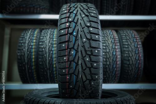 Winter tire on the background of racks with tires