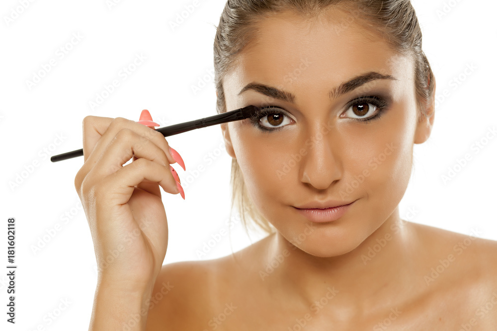 young beautiful woman applied eyeshadow with a brush young beautiful woman applied eyeshadow with a brush