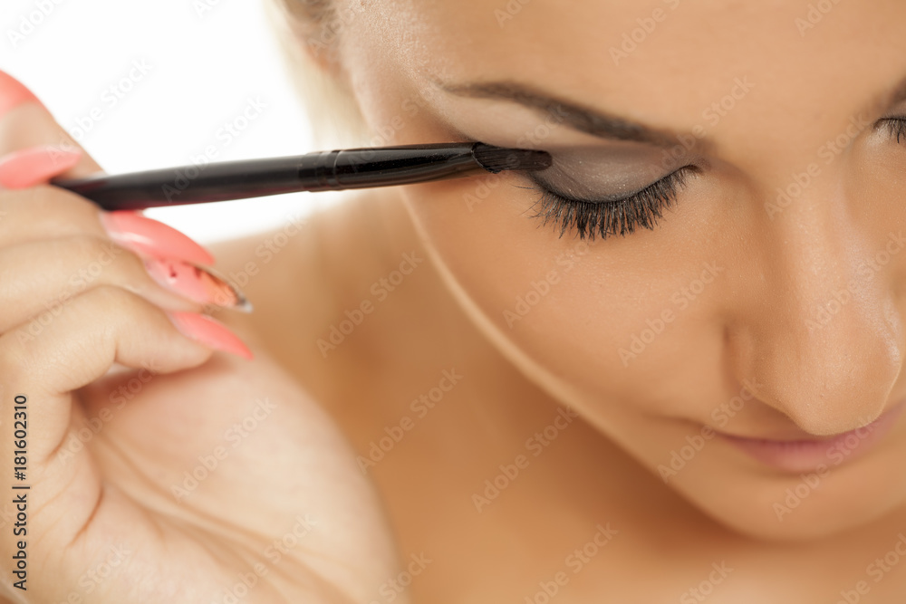 young beautiful woman applied eyeshadow with a brush
