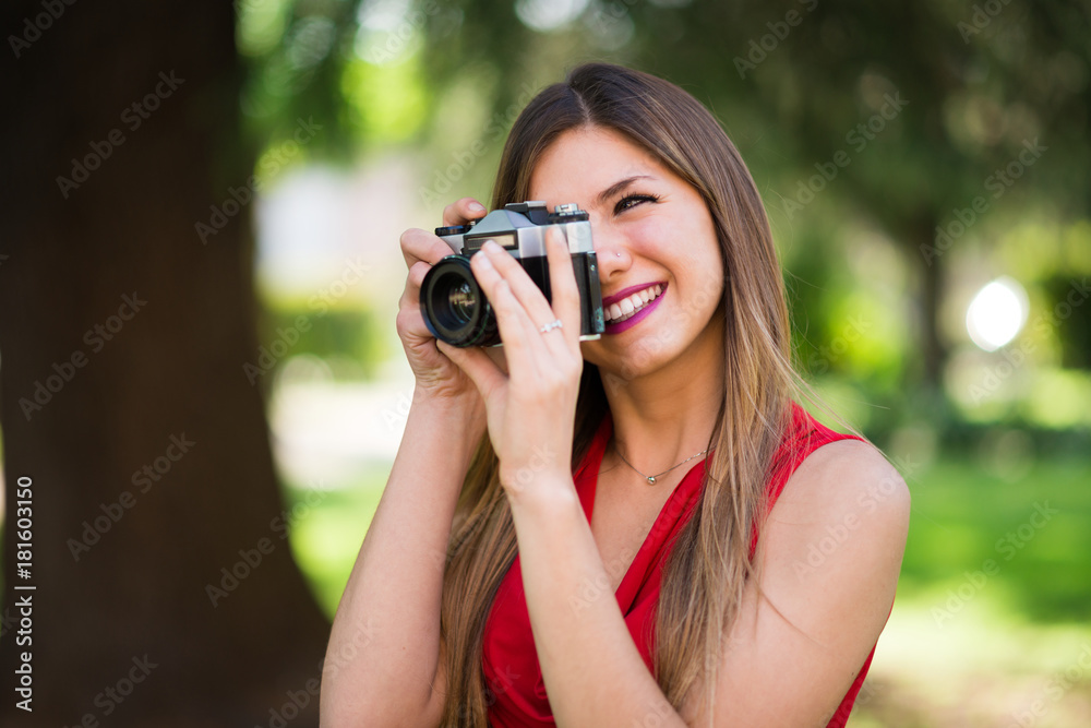 Smiling young woman using a camera