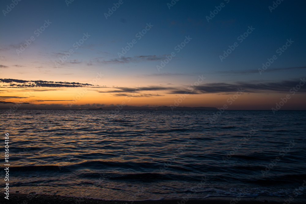 Obraz premium Orange Sunset Above Dark Water of Sea.