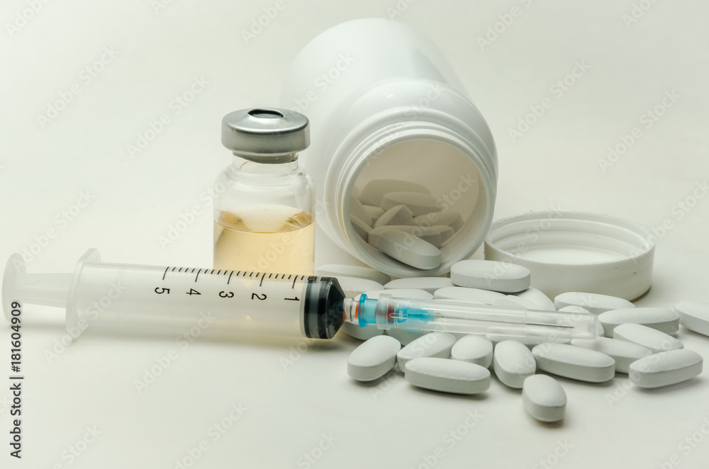 Pills, vitamins and syringe for injection with medications isolated on white background Pills, vitamins and syringe for injection with medications isolated on white background