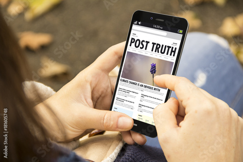 woman with post truth phone in the park