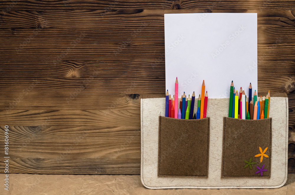 Obraz premium Color pencils and blank page paper with copy space in a bag pocket. Drawing set. Artist bag. Certificate of the artist mock up.