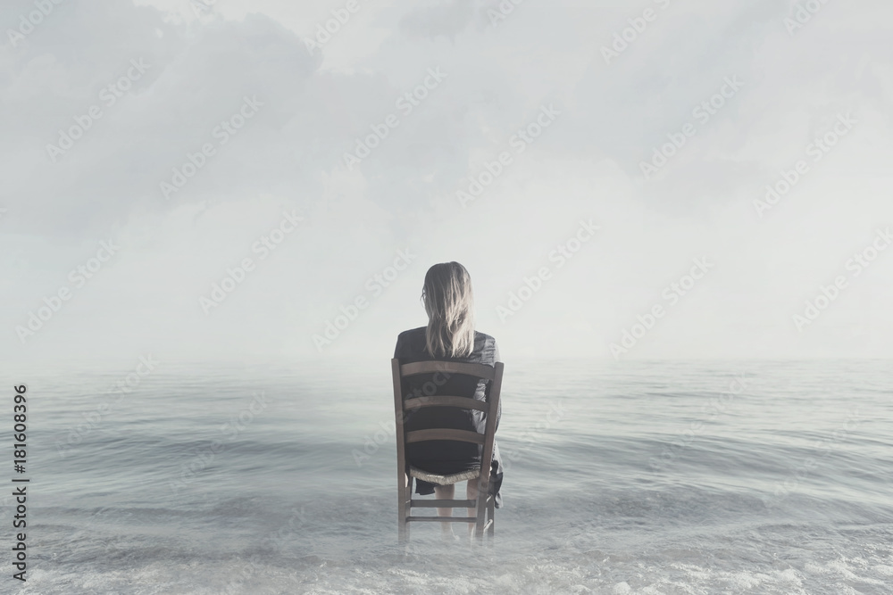 lonely woman sitting on shore at the ocean looks at infinity