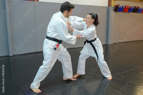 woman and man judo fighters in sport hall