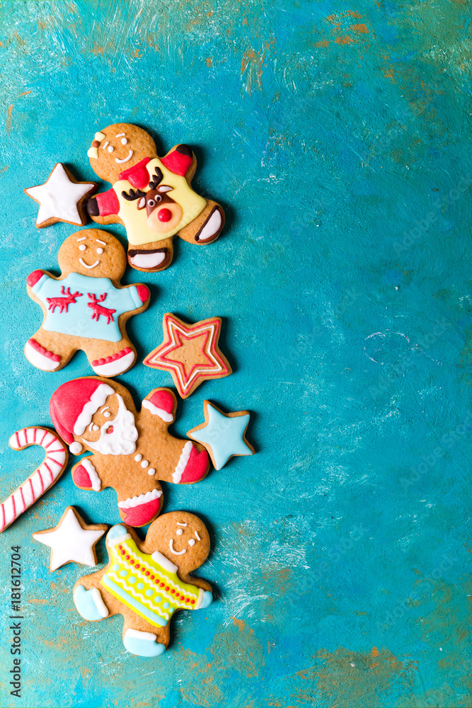  Ginger men with colored glaze on a turquoise background .. Gingerbread. Christmas cookies. Ginger man in a colored sweater. Gingerbread Santa
