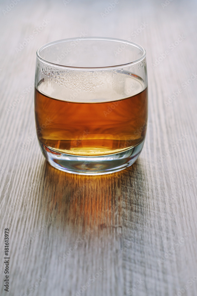 Hot tea in a glass, on a wooden table, in backlight. Hot tea in a glass, on a wooden table, in backlight.