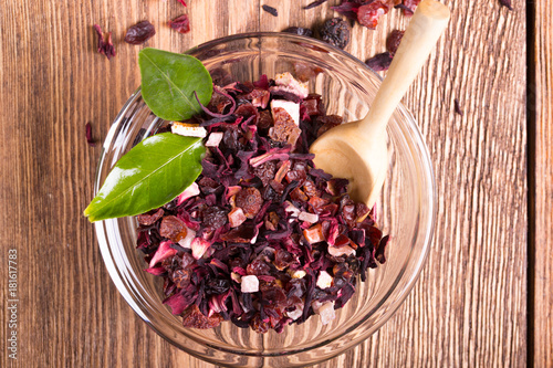 Herbal aroma fruit tea dry leaves on spoon on wooden background photo