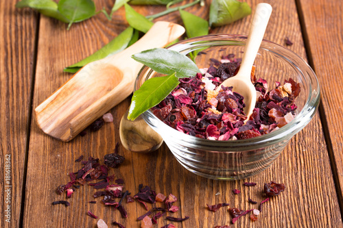 Fototapeta Naklejka Na Ścianę i Meble -  Herbal aroma fruit tea dry leaves on spoon on wooden background