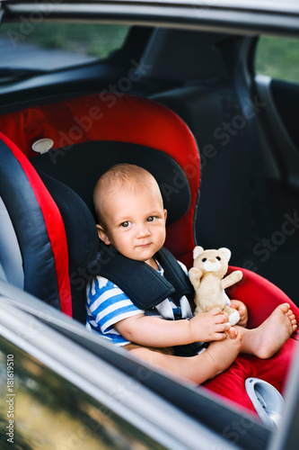 Canvastavla Little baby boy sitting in the car seat in the car.