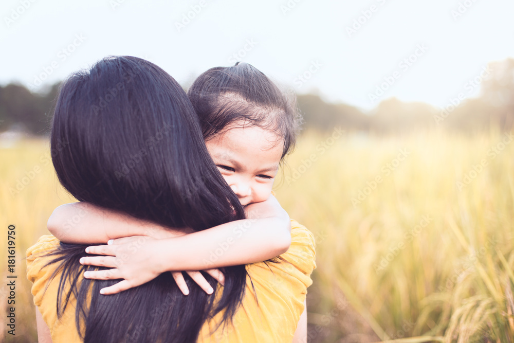 happy asian little child girl hugging her mother with love in the paddy field in vintage color tone happy asian little child girl hugging her mother with love in the paddy field in vintage color tone