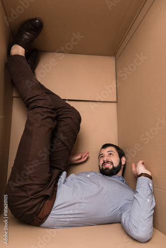 depressed man in cardboard box