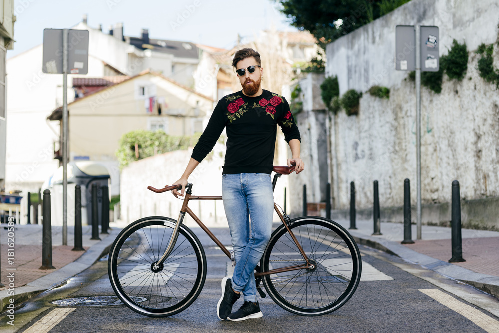 Stylish man with bicycle on street