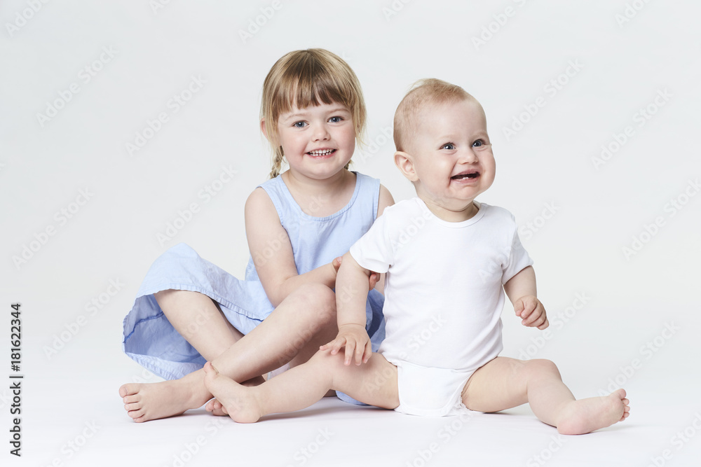 Funny brother and sister smiling in white studio Funny brother and sister smiling in white studio