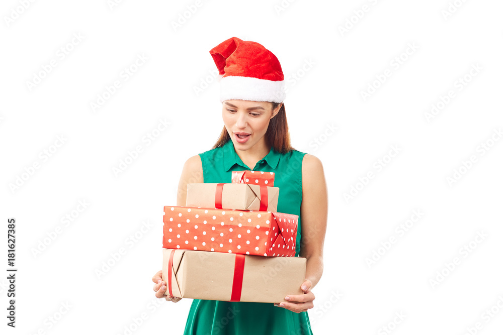 Portrait of young womanin Santa hat holding stack of Christmas gifts on white background Portrait of young womanin Santa hat holding stack of Christmas gifts on white background