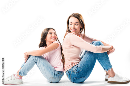 daughter and mother sitting back to back