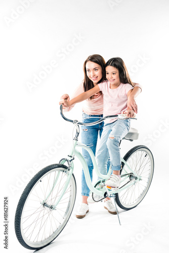 Mother teaching daughter riding bicycle
