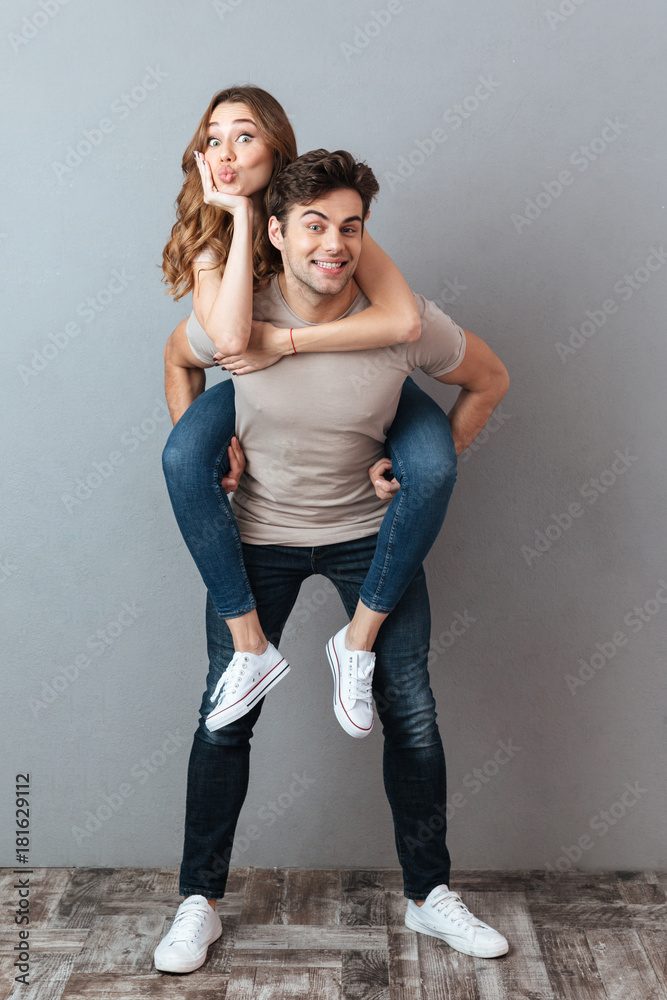 Full length portrait of a cheerful man carrying girlfriend Full length portrait of a cheerful man carrying girlfriend