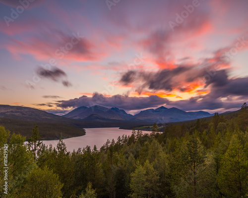 Beautiful sunset overlooking a forest and a lake in Rondane National Park, Norway