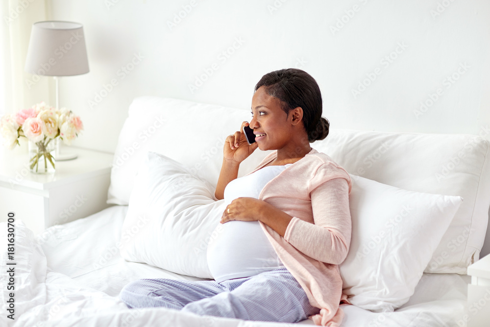 happy pregnant woman calling on smartphone at home