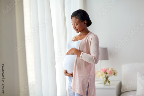фотографія pregnant african american woman at home window