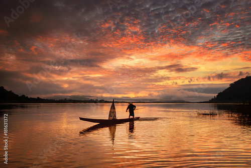 Silhouette fisherman on during sunset,during sunrise,Thailand © saravut