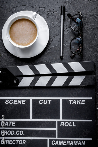 Screenwriter desktop with movie clapper board dark background to