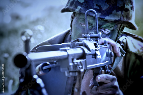 Soldier with a machine gun lying on the ground