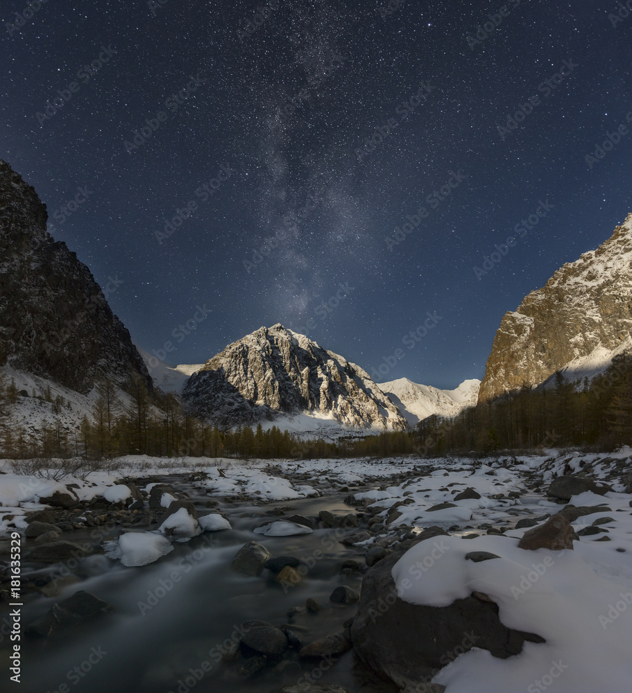 Fototapeta premium Fantastic starry sky. Autumn landscape and snow-capped peaks