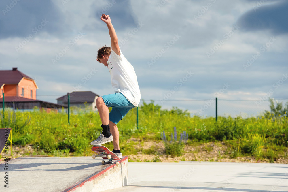 Fototapeta premium A boy in a skate park doing a trick on a skateboard