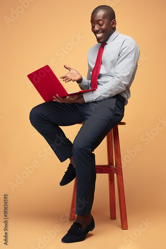Handsome Afro American man sitting and using a laptop