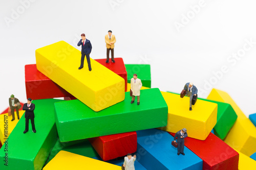 Businessman standing on wooden blocks color  used as a concept of business position.