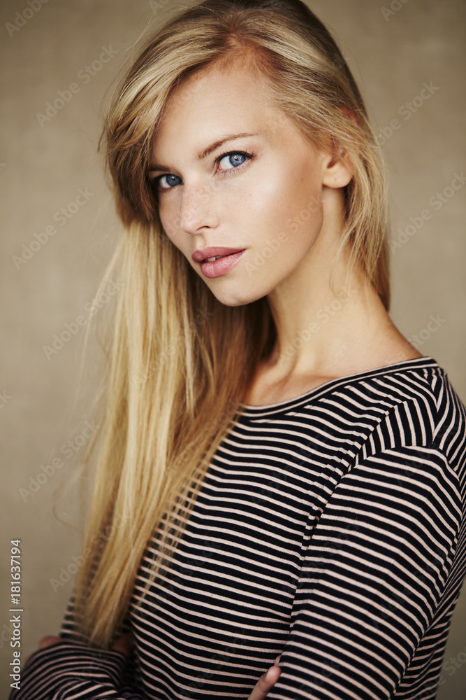 Fototapeta premium Stunning young blond woman in striped top, portrait