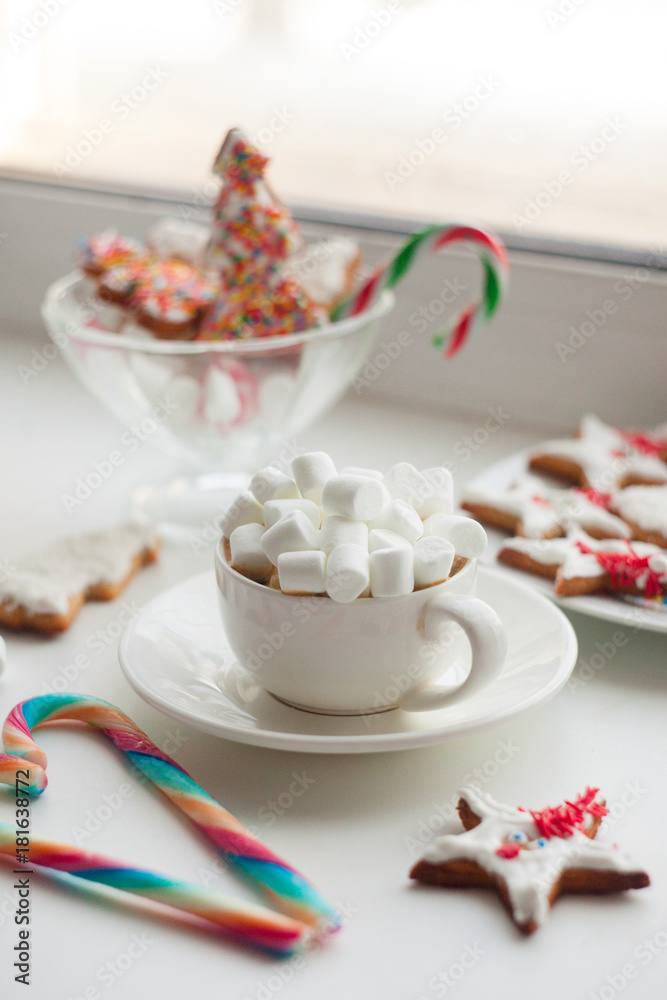 Cozy winter still life: cup of cocoa with marshmallows, sweets, cookies on windowsill Cozy winter still life: cup of cocoa with marshmallows, sweets, cookies on windowsill