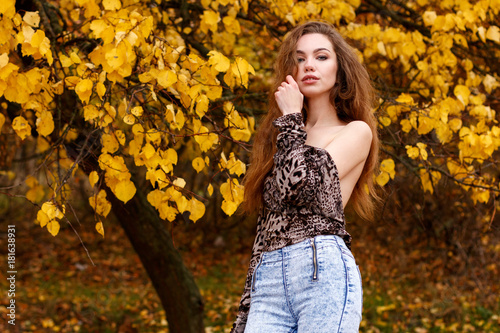 Topless young girl with long brown hair in autumn park