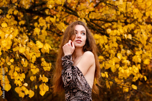 Topless young girl with long brown hair in autumn park