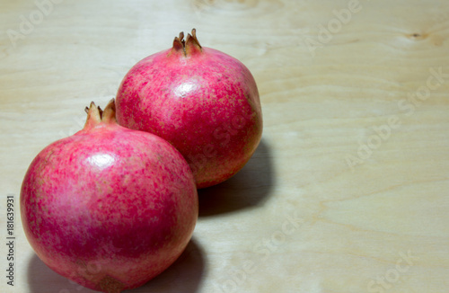 large red pomegranates on wooden background with selective focus