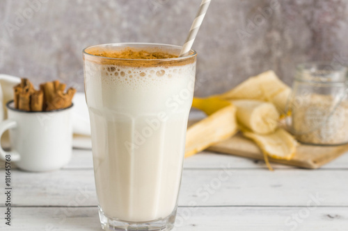 Stampa su tela Banana oat protein shake with cinnamon and paper straw in a glass