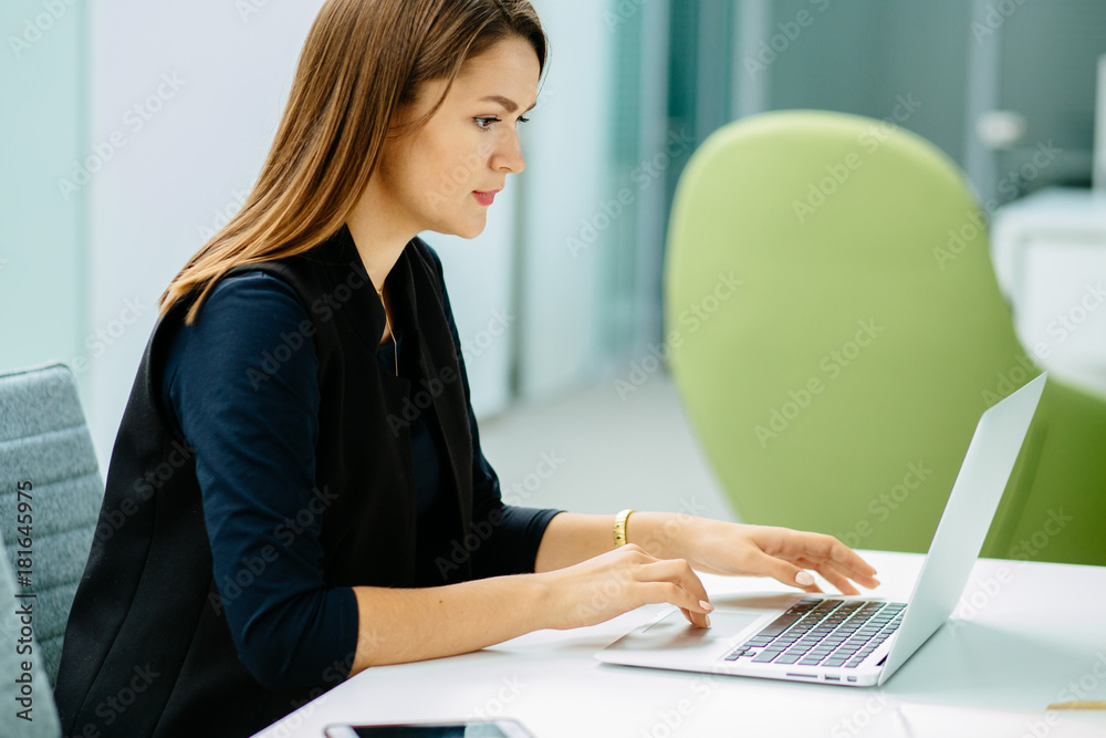 Young business woman manager working on tablet computer, surfing internet in comfortable office interior and preparing to business meeting. Young business woman manager working on tablet computer, surfing internet in comfortable office interior and preparing to business meeting.
