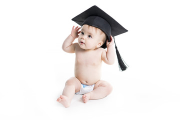 Portrait of a sitting baby girl with a graduation cap