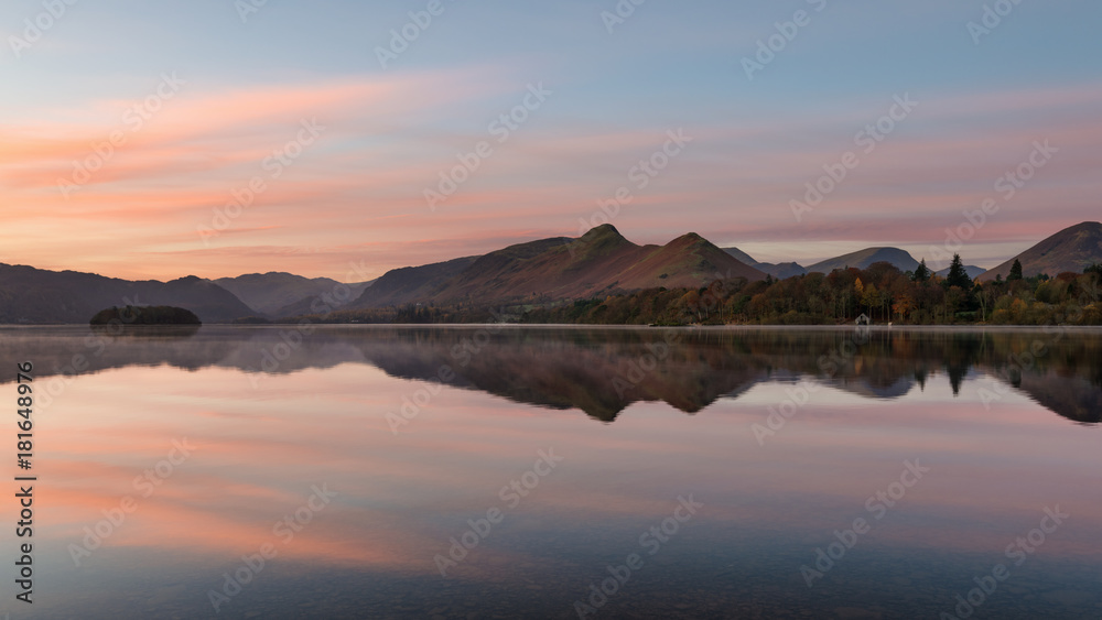 Pink and orange sunrise reflections at Derwentwater in the English Lake District.