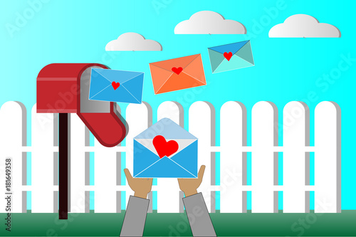 Hands are picking up the envelope for the mailbox.