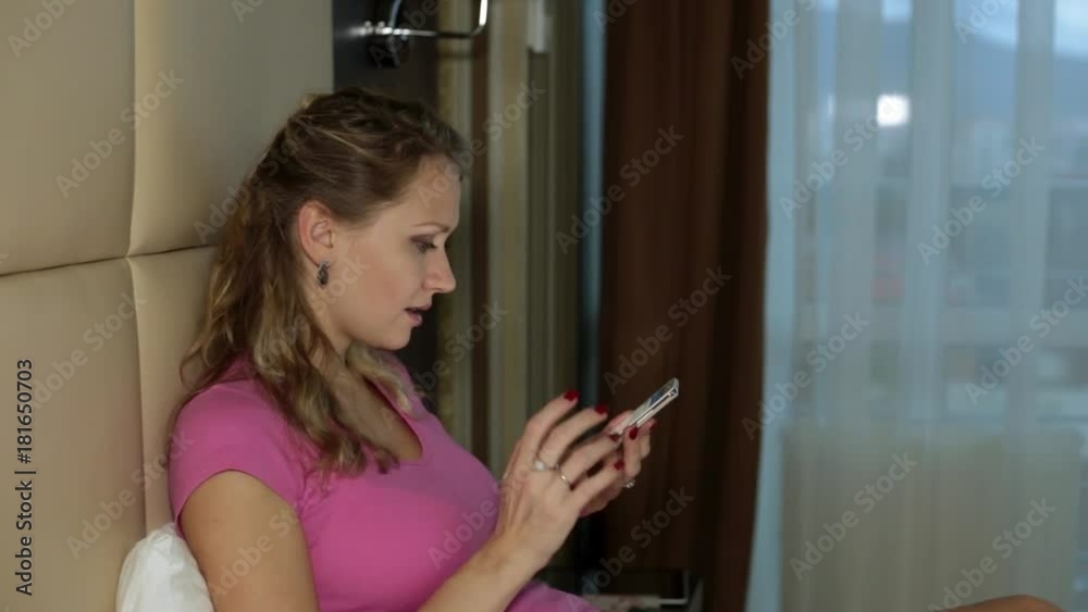 Woman with a smartphone on the bed. Woman with a smartphone on the bed.