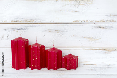 Christmas Card with Red Candles on a White Wooden Background