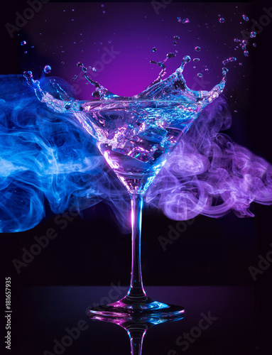 martini cocktail splashing on smoky blue and purple background