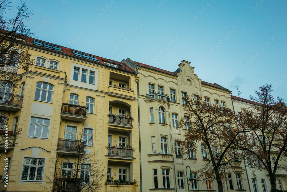yellow apartment buildings in berlin with blue sky